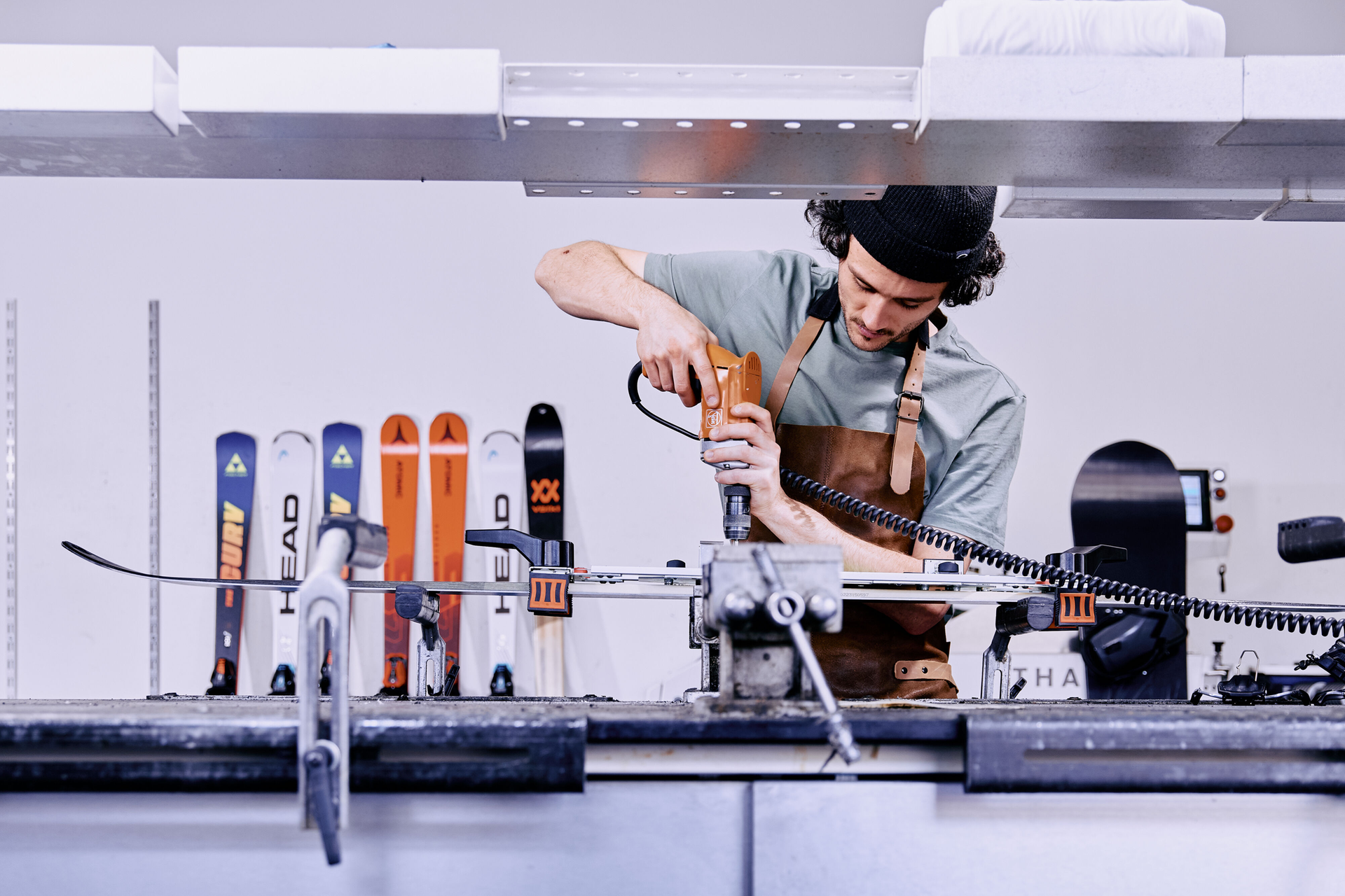 Employee standing next to a ski service machine